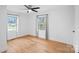 Bright bedroom with hardwood floors, two windows and a ceiling fan at 6301 Vernedale Rd, Charlotte, NC 28212