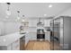 Bright kitchen with stainless steel appliances, quartz countertops, and hardwood floors, perfect for cooking and gatherings at 6301 Vernedale Rd, Charlotte, NC 28212