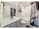 Well-lit bathroom features a light blue vanity, toilet, and shower/tub combination with patterned shower curtain at 6708 Burning Oak Ln, Charlotte, NC 28216