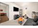 Comfortable living room showing neutral tones, mounted TV, and open access to other rooms at 6708 Burning Oak Ln, Charlotte, NC 28216