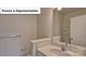 Well-lit bathroom featuring quartz countertops, framed mirror, and chrome hardware at 8018 Kennesaw Dr, Gastonia, NC 28056