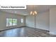 Bright and airy living room with modern chandelier, window views, and hardwood flooring at 8018 Kennesaw Dr, Gastonia, NC 28056