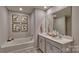 Bathroom featuring dual sinks, a soaking tub, and modern fixtures at 8073 Kennesaw Dr, Gastonia, NC 28056