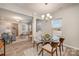 Dining area with stylish lighting fixture and adjoins a living area, wood-look floors, and neutral walls at 8573 River Ridge Dr, Charlotte, NC 28213