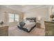 Comfortable main bedroom features a tray ceiling, soft carpet, and neutral decor at 8573 River Ridge Dr, Charlotte, NC 28213