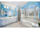 Bathroom displaying a shower, a bathtub, double vanity and a window bringing natural light to this area at 9200 Four Acre Ct, Charlotte, NC 28210