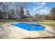 Backyard features a gunite pool with a concrete surround and two chairs on the green grass at 9200 Four Acre Ct, Charlotte, NC 28210