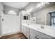 A bright bathroom featuring double sinks, a large mirror, and white cabinets at 10011 Forest View Ln, Charlotte, NC 28213