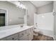 Bright bathroom featuring a double sink vanity, large mirror, and bathtub-shower combination at 10011 Forest View Ln, Charlotte, NC 28213