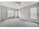 Bright bedroom with neutral walls, carpet, a ceiling fan, and multiple windows at 10011 Forest View Ln, Charlotte, NC 28213