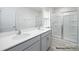 Bright bathroom featuring a double vanity with sleek gray cabinets and a glass-enclosed shower at 1032 Hostler Ln, York, SC 29745