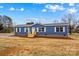 Inviting blue manufactured home with white trim and new porch steps in a rural setting at 114 Hallmark Estates Dr, Statesville, NC 28625