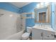 Bright bathroom featuring a shower-tub combo, white vanity, and blue walls at 11712 Huxley Rd, Charlotte, NC 28277