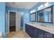 Bright blue bathroom featuring a double vanity with marble countertop and tiled floors at 11712 Huxley Rd, Charlotte, NC 28277