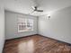 Comfortable bedroom featuring ceiling fan, window and wood-look flooring at 11712 Huxley Rd, Charlotte, NC 28277