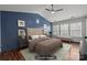 This staged bedroom features wood-look flooring, ceiling fan, furnishings, and multiple windows at 11712 Huxley Rd, Charlotte, NC 28277