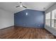 Well lit bedroom features wood-look flooring, a ceiling fan, and multiple windows at 11712 Huxley Rd, Charlotte, NC 28277