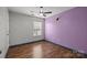 Cozy bedroom featuring a ceiling fan, window and wood-look flooring at 11712 Huxley Rd, Charlotte, NC 28277