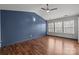 Well lit bedroom features wood-look flooring, a ceiling fan, and multiple windows at 11712 Huxley Rd, Charlotte, NC 28277