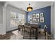 Dining room featuring hardwood floors, a modern light fixture, table with seating for six, and natural lighting at 11712 Huxley Rd, Charlotte, NC 28277