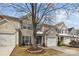 Charming two-story home featuring beige siding, blue shutters, and a well-manicured front yard with a driveway and garage at 11712 Huxley Rd, Charlotte, NC 28277