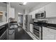 Modern kitchen featuring marble floors, stainless steel appliances, white cabinets, and lots of natural lighting from backyard at 11712 Huxley Rd, Charlotte, NC 28277