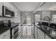 Modern kitchen featuring marble floors, stainless steel appliances, white cabinets, and lots of natural lighting from backyard at 11712 Huxley Rd, Charlotte, NC 28277