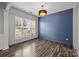 Bright living room with light gray walls, hardwood floors, and modern lighting fixtures, perfect for entertaining and relaxing at 11712 Huxley Rd, Charlotte, NC 28277