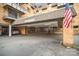 Exterior view of a brick apartment building with covered parking and building access with American flag at 1323 Queens Rd # 202, Charlotte, NC 28207