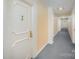 Hallway with neutral walls, gray carpet, doors, and overhead lighting fixtures at 1323 Queens Rd # 202, Charlotte, NC 28207