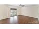 Spacious living room with dark wood floors, ceiling fan, and a sliding door to a balcony at 1323 Queens Rd # 202, Charlotte, NC 28207