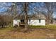 Backyard view of the house with a deck and mature trees at 1707 W 4Th Ave, Gastonia, NC 28052