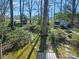 Landscaped backyard with lush greenery, a stone pathway, and a storage shed at 1906 Overhill Dr, Monroe, NC 28110