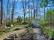 Serene backyard featuring a fire pit, seating, and a pathway leading to a storage shed at 1906 Overhill Dr, Monroe, NC 28110