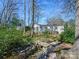 Picturesque backyard featuring a small wooden bridge over a creek and lush landscaping at 1906 Overhill Dr, Monroe, NC 28110