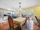 Open dining area featuring hardwood floors, decorative light fixture, and easy access to the kitchen and the patio at 1906 Overhill Dr, Monroe, NC 28110