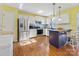 Bright kitchen featuring white cabinets, stainless steel appliances, a breakfast bar, and hardwood floors at 1906 Overhill Dr, Monroe, NC 28110