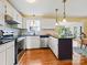 This bright kitchen offers stainless steel appliances, granite countertops, white cabinetry, and hardwood floors at 1906 Overhill Dr, Monroe, NC 28110