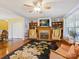 Spacious living room with a decorative fireplace, hardwood floors, built-in bookcases, and a ceiling fan at 1906 Overhill Dr, Monroe, NC 28110