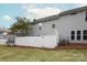 Backyard area featuring a white fence, grass, and a gray home at 1915 Colony Line Ct, Charlotte, NC 28210