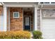 Inviting front entrance of townhome featuring stone accents, a black front door, and fresh landscaping at 1915 Colony Line Ct, Charlotte, NC 28210