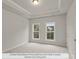 Main bedroom with tray ceiling, carpet floors, and two large windows offering lots of natural light at 214 Gilead Rd, Huntersville, NC 28078