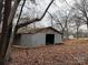 Image of a gray barn with an opening on a property covered with fallen leaves at 2211 Unionville Indian Trl, Indian Trail, NC 28079