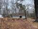 Exterior view of metal building in a wooded area, with a corrugated roof at 2211 Unionville Indian Trl, Indian Trail, NC 28079