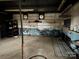 View inside the garage, including its peeling paint, shelving, and metal garage door at 2211 Unionville Indian Trl, Indian Trail, NC 28079