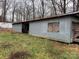 Exterior view of a long metal building with boarded up windows and tall weeds at 2211 Unionville Indian Trl, Indian Trail, NC 28079