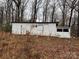 Image of white outbuilding surrounded by grass and fallen leaves at 2211 Unionville Indian Trl, Indian Trail, NC 28079