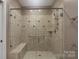 Elegant tiled shower features glass doors, bench and showerhead at 2227 Cashmere Ct, Denver, NC 28037