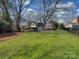 Expansive backyard with lush lawn, mature trees, and well-maintained landscaping, creating a serene outdoor space at 2326 Lathrop Ln, Charlotte, NC 28211