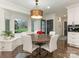 Cozy breakfast nook with a round wood table, built-in bench, and natural light from a large window at 2326 Lathrop Ln, Charlotte, NC 28211